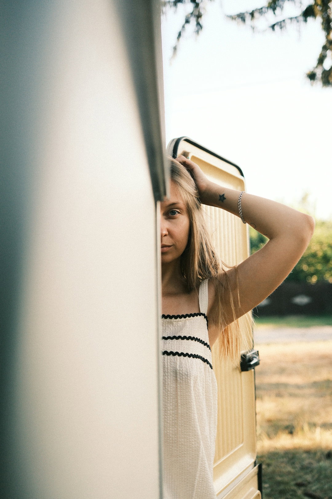 a-woman-with-a-star-tattoo-on-her-wrist-peeking-from-behind-a-door.jpg A woman with a star tattoo on her wrist peeking from behind a door